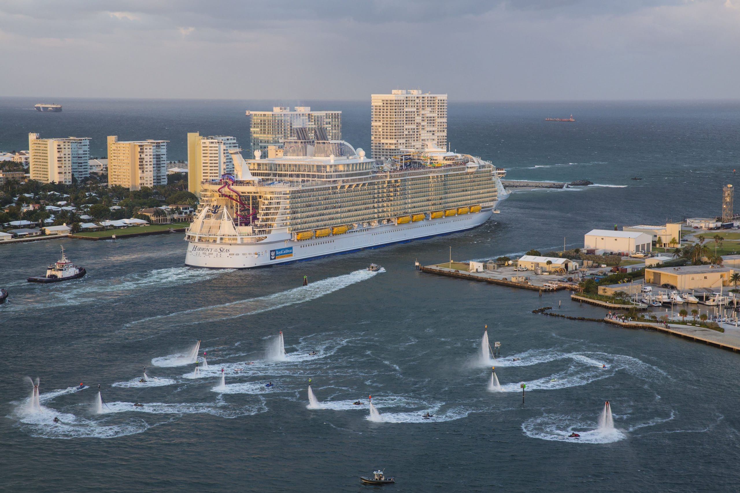 HM, aerials, Three Sisters event, Harmony of the Seas sails on maiden voyage out of Port Everglades, Fort Lauderdale, Nov 5, 2016, rear view, starboard side, port buildings, ocean view in background, flotilla send-off, team of 16 jetboard and jetpack riders from Aquafly Hydroflight Sports Performance Team,